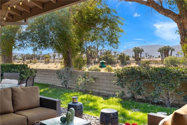 view of yard with a mountain view, a fenced backyard, and an outdoor living space