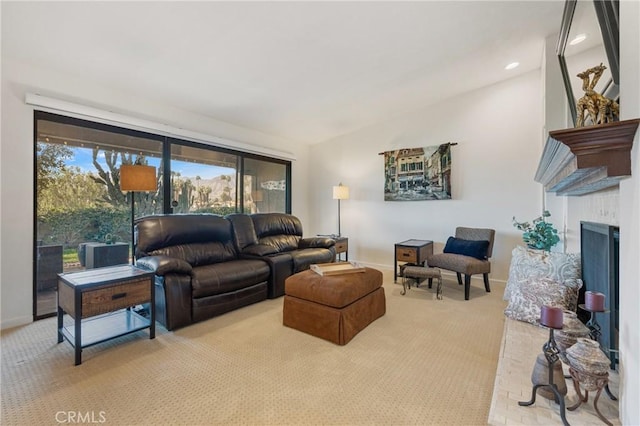 living area with lofted ceiling, light colored carpet, a fireplace, and baseboards