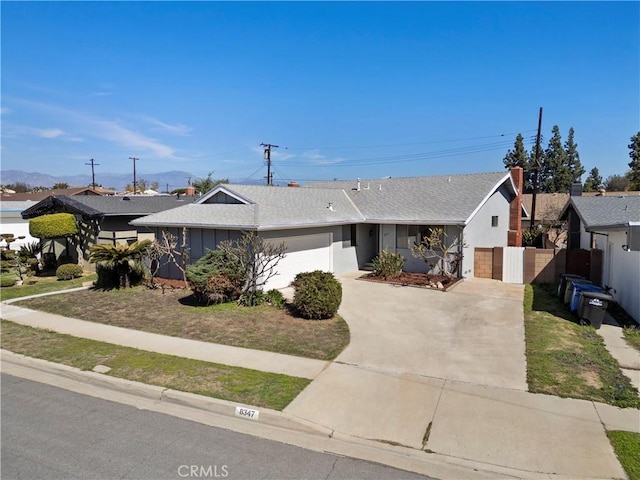 ranch-style home with a garage, roof with shingles, driveway, and fence