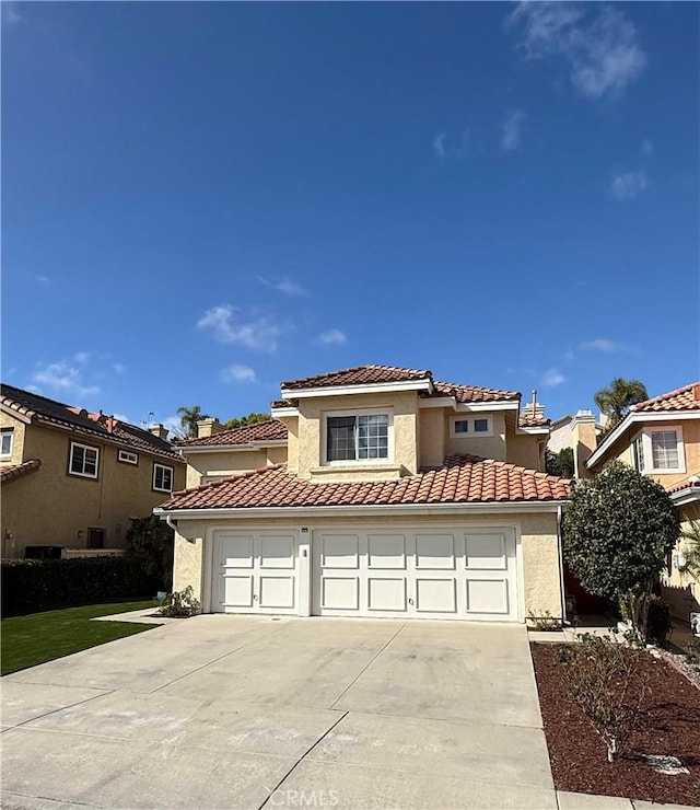 mediterranean / spanish-style home featuring concrete driveway, a tile roof, an attached garage, and stucco siding