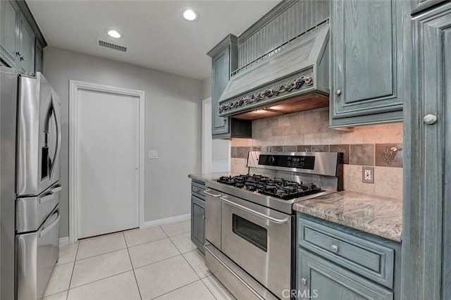 kitchen featuring light tile patterned floors, stainless steel appliances, premium range hood, visible vents, and decorative backsplash