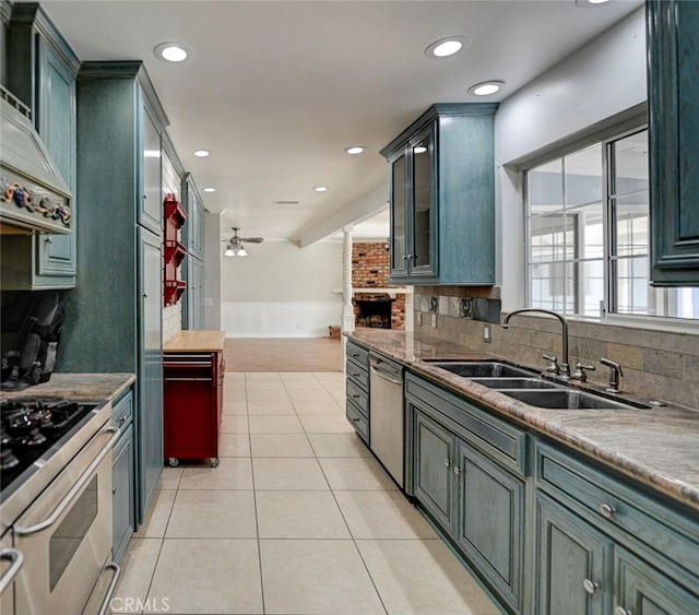 kitchen with decorative backsplash, appliances with stainless steel finishes, light tile patterned flooring, a sink, and recessed lighting