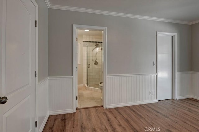 interior space featuring wainscoting, crown molding, and wood finished floors