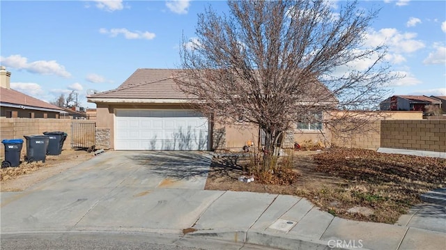 single story home featuring a garage, fence, driveway, a tiled roof, and stucco siding