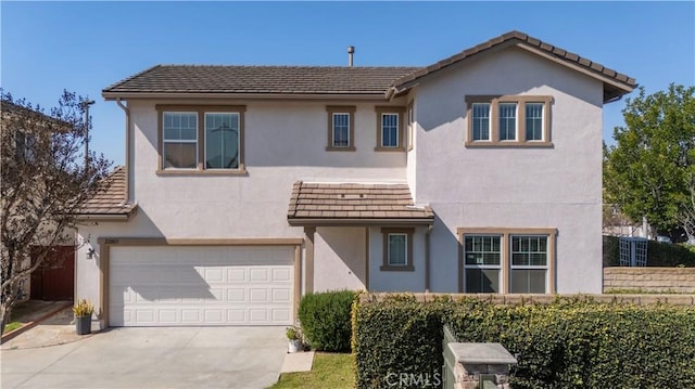 traditional home with a tile roof, driveway, an attached garage, and stucco siding