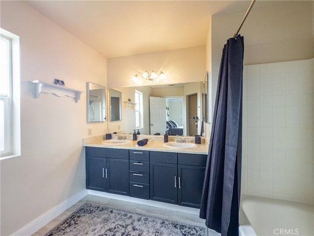 ensuite bathroom with double vanity, tile patterned flooring, a sink, and ensuite bathroom