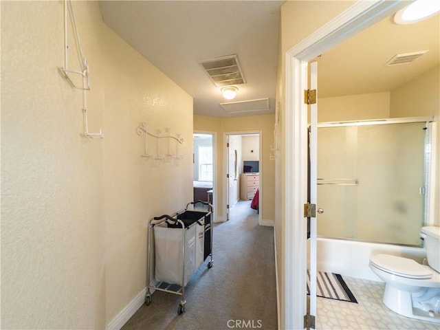 full bath with toilet, bath / shower combo with glass door, visible vents, and baseboards