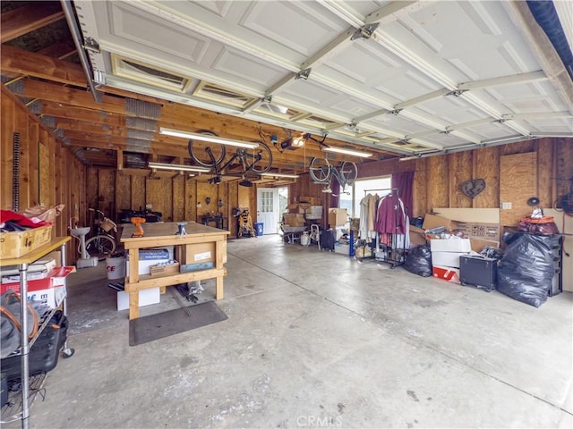 garage with wood walls, a workshop area, and a garage door opener