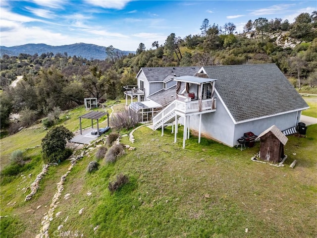 birds eye view of property featuring a mountain view and a wooded view