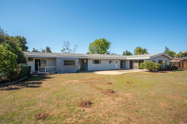 view of front of property with a front lawn, a patio area, and fence