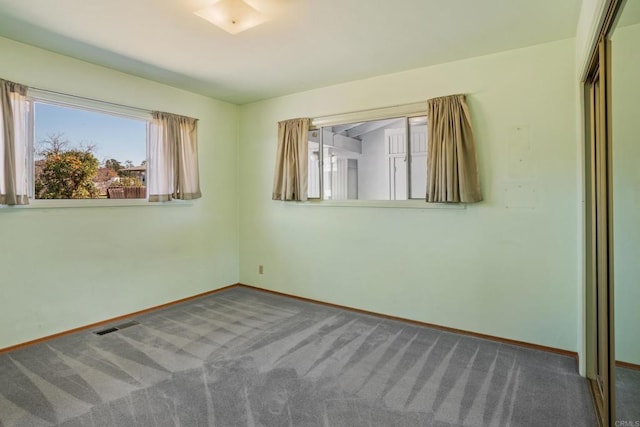 unfurnished bedroom with carpet floors, a closet, visible vents, and baseboards