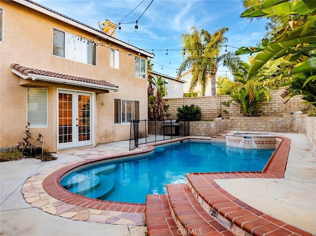 view of swimming pool with a patio, french doors, a fenced backyard, and a pool with connected hot tub