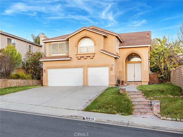 mediterranean / spanish house featuring concrete driveway, a tiled roof, an attached garage, and stucco siding