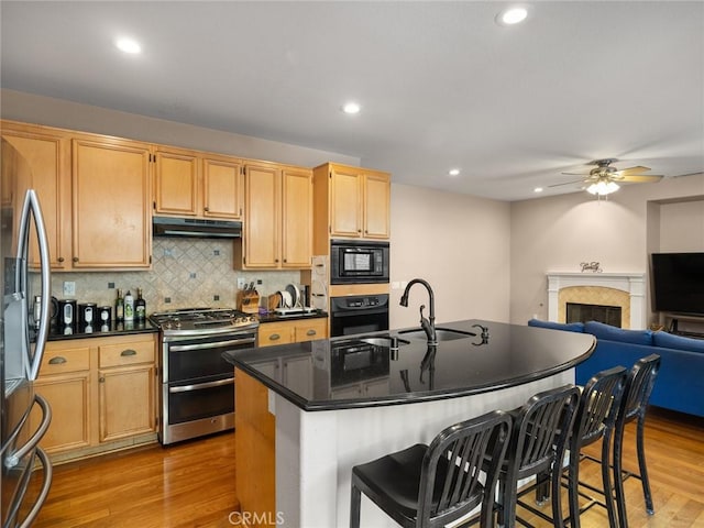 30514 Sorrento Pl, Castaic, CA 91384 - kitchen with black appliances, under cabinet range hood, ceiling fan, open floor plan, and light wood finished floors