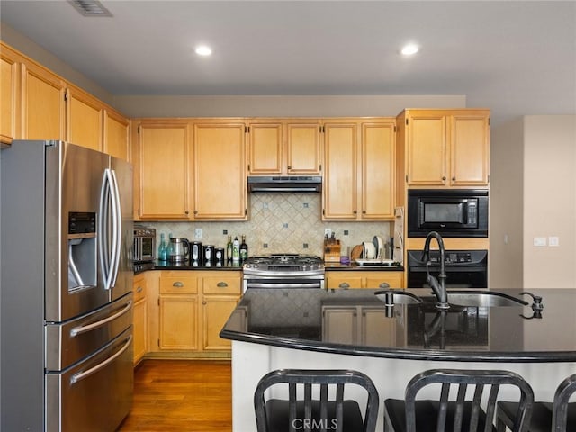 30514 Sorrento Pl, Castaic, CA 91384 - kitchen with black appliances, under cabinet range hood, dark wood-style flooring, recessed lighting, and backsplash