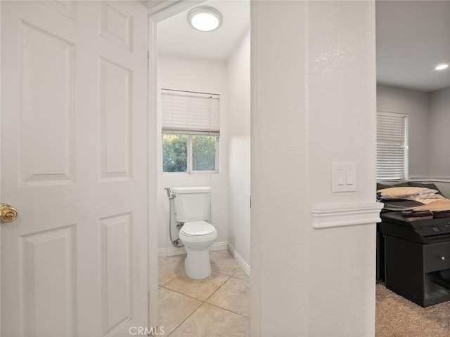 bathroom with toilet, tile patterned flooring, and baseboards