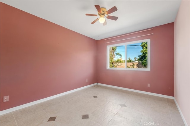 spare room with ceiling fan, baseboards, and light tile patterned floors