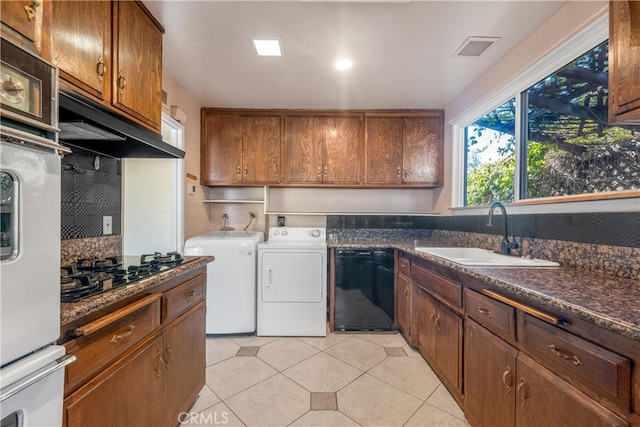 kitchen featuring washer and clothes dryer, dark countertops, visible vents, a sink, and black appliances