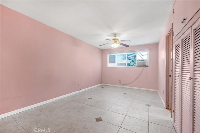 unfurnished bedroom featuring light tile patterned floors, ceiling fan, cooling unit, baseboards, and a closet