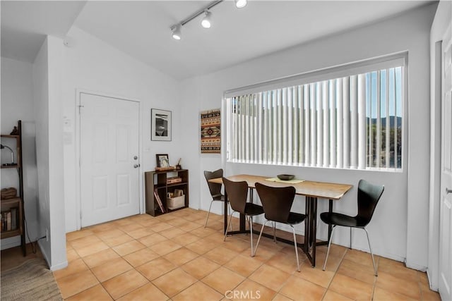 dining area with light tile patterned floors, breakfast area, vaulted ceiling, and a wealth of natural light