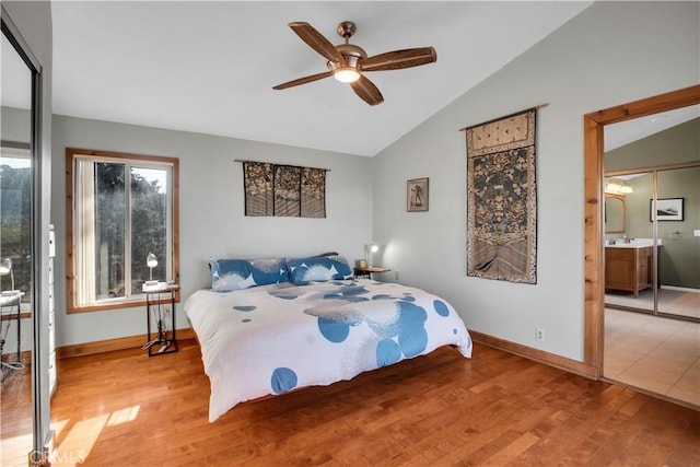 bedroom with lofted ceiling, baseboards, and wood finished floors