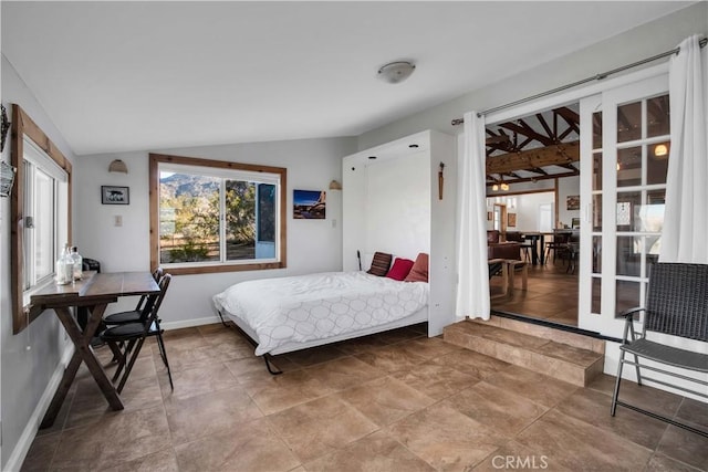 bedroom featuring lofted ceiling and baseboards