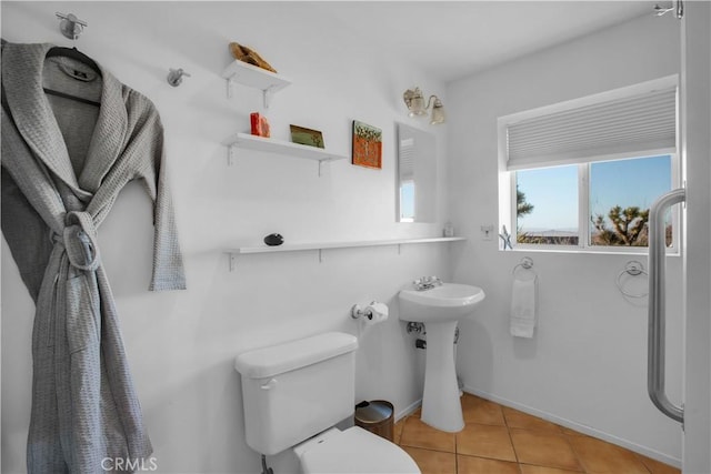 bathroom featuring toilet, tile patterned flooring, and baseboards