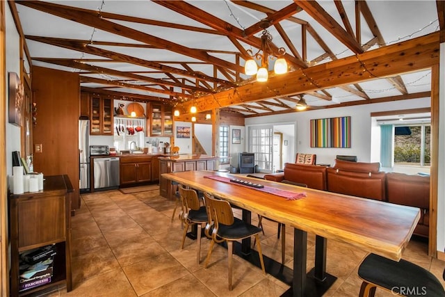 dining area featuring lofted ceiling with beams and light tile patterned floors