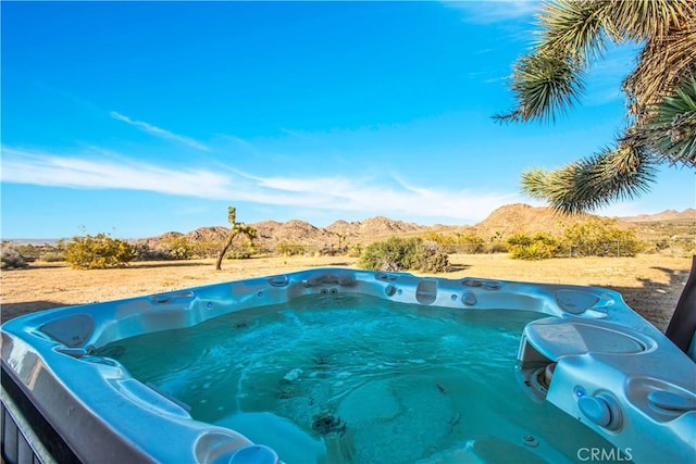 view of swimming pool featuring a hot tub and a mountain view