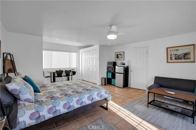 tiled bedroom with freestanding refrigerator, a closet, and ceiling fan