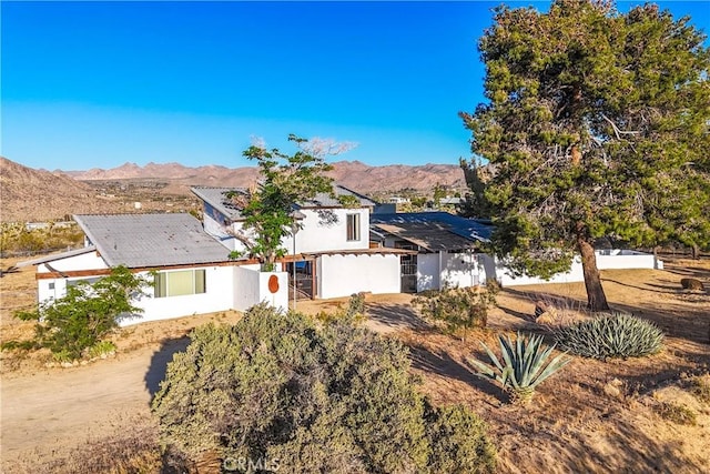 view of front of property with solar panels, fence, and a mountain view