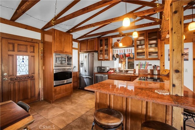 kitchen featuring stone counters, stainless steel appliances, a peninsula, brown cabinets, and glass insert cabinets