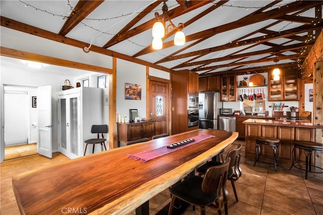 tiled dining area with lofted ceiling with beams