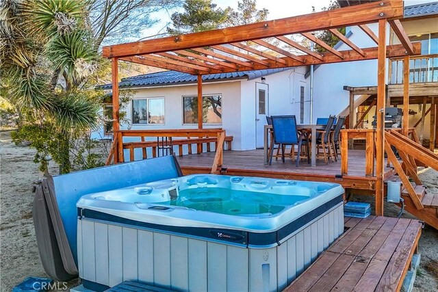 wooden terrace with a hot tub, outdoor dining area, and a pergola