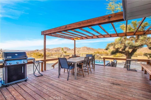 wooden terrace with a mountain view, grilling area, and outdoor dining space