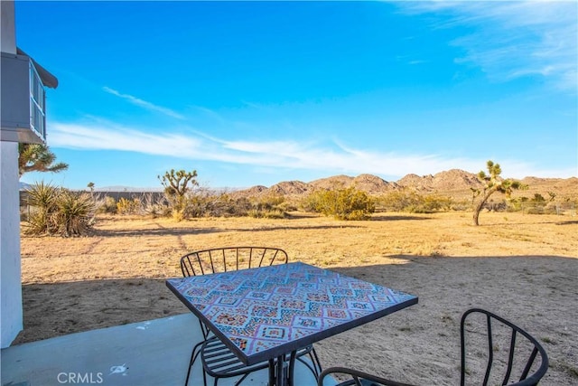 view of patio / terrace with outdoor dining area and a mountain view