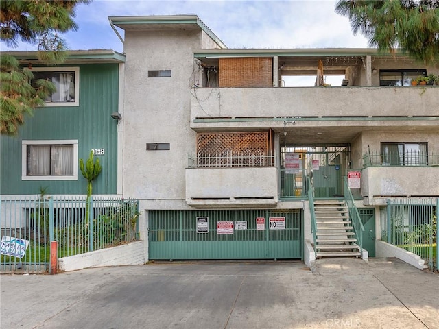 view of building exterior with stairs and fence