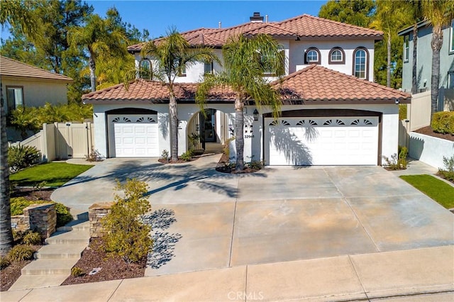 mediterranean / spanish-style home featuring a tile roof, stucco siding, a garage, and a chimney