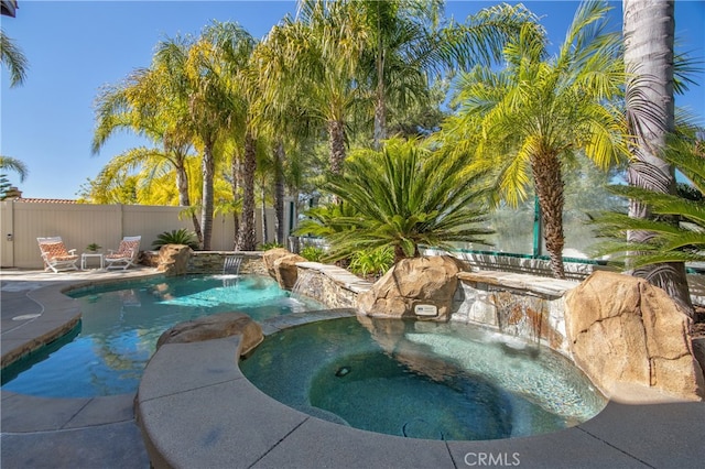 view of swimming pool featuring an in ground hot tub, a fenced in pool, and fence