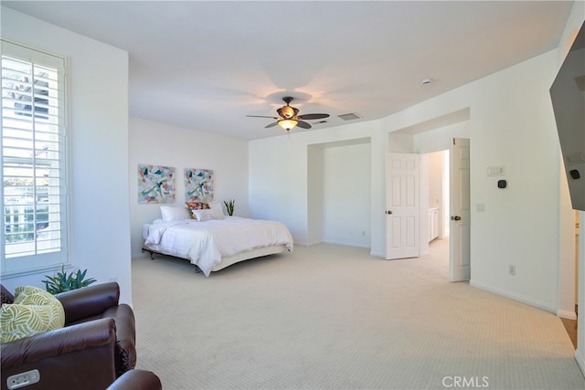 bedroom with baseboards, a ceiling fan, visible vents, and light carpet