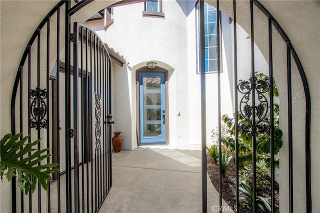 doorway to property featuring a gate and stucco siding