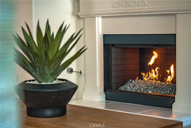 interior details featuring backsplash and a tiled fireplace