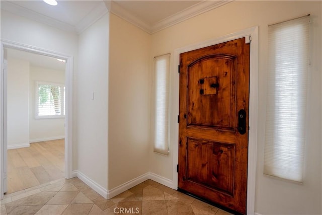 entryway with baseboards, crown molding, and light tile patterned flooring