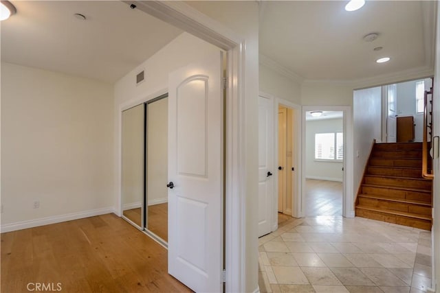 hall with visible vents, stairs, baseboards, and crown molding