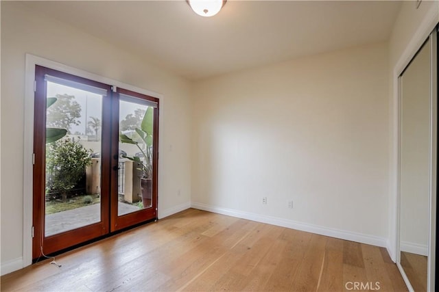 entryway featuring baseboards, french doors, and light wood-style floors