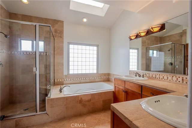 bathroom with a stall shower, lofted ceiling with skylight, tile patterned flooring, vanity, and a bath