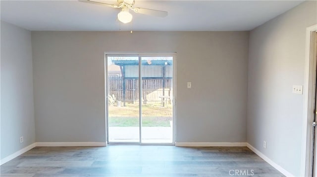 empty room featuring light wood-style floors, ceiling fan, and baseboards