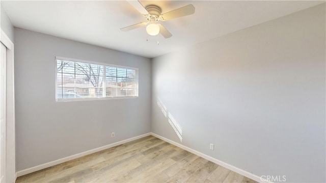 empty room featuring light wood-type flooring, ceiling fan, and baseboards