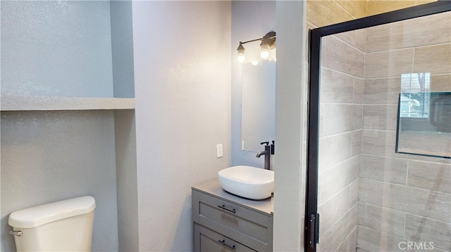 full bathroom with a stall shower, vanity, and toilet