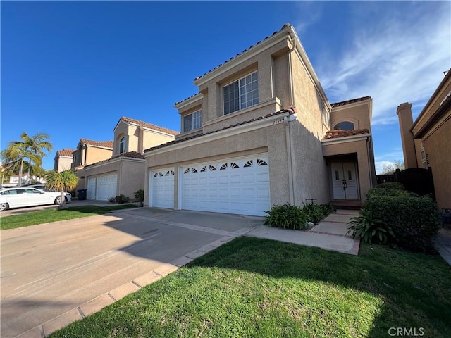 view of front of house featuring driveway, an attached garage, a front yard, and stucco siding